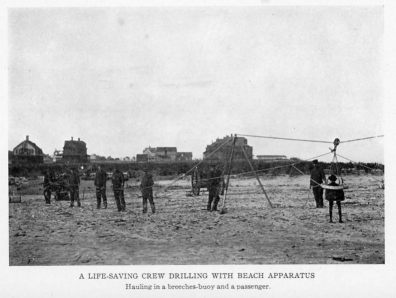 A LIFE-SAVING CREW DRILLING WITH BEACH APPARATUS
Hauling in a breeches-buoy and a passenger.